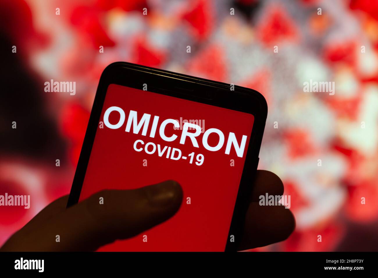 In questa illustrazione, uno schermo del telefono mostra un testo che dice Omicron COVID-19. Foto Stock