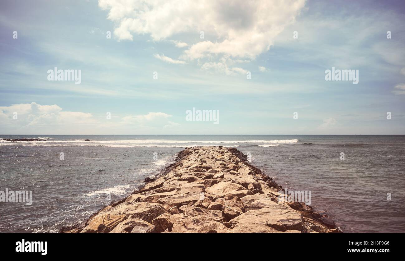 Molo roccioso in mare in una giornata estiva soleggiata, tonificante applicato, Sri Lanka. Foto Stock