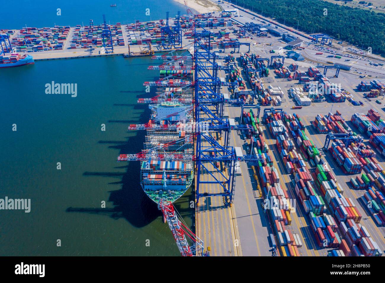 Carico di container al porto con gru, container con container per l'importazione e l'esportazione logistica aziendale e trasporto, vista aerea dall'alto. Foto Stock