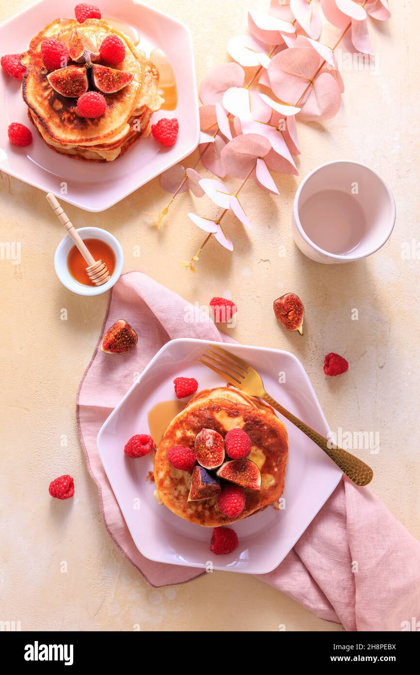 Syrniki - pancake al formaggio di quark o curd dolce con lampone fresco, fichi e acero sirup Foto Stock