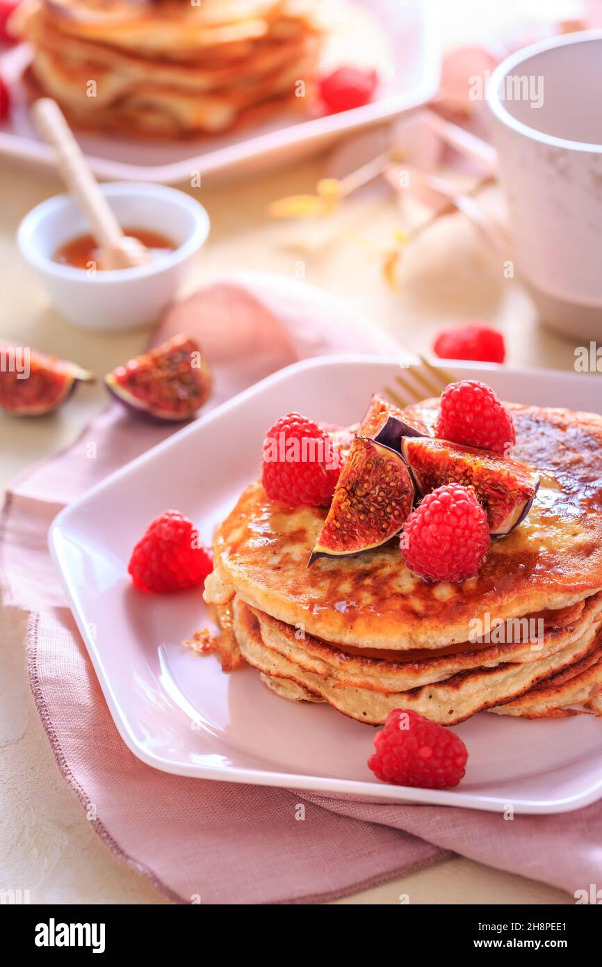 Syrniki - pancake al formaggio di quark o curd dolce con lampone fresco, fichi e acero sirup Foto Stock