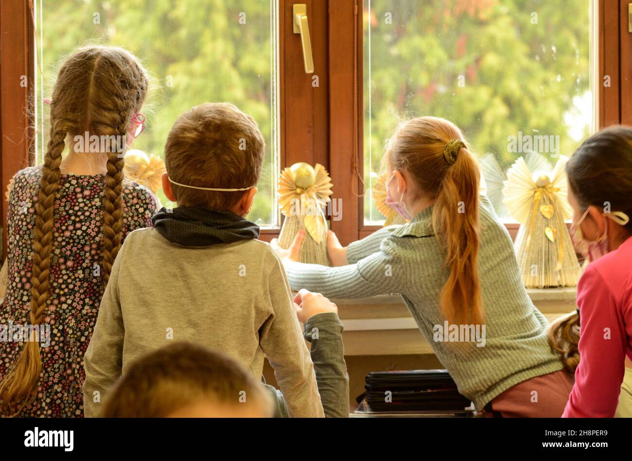 bambini a scuola, alunni in classe, fatto angeli , angelo da carta, libro riciclato, angelo, natale, preparandosi per natale Foto Stock