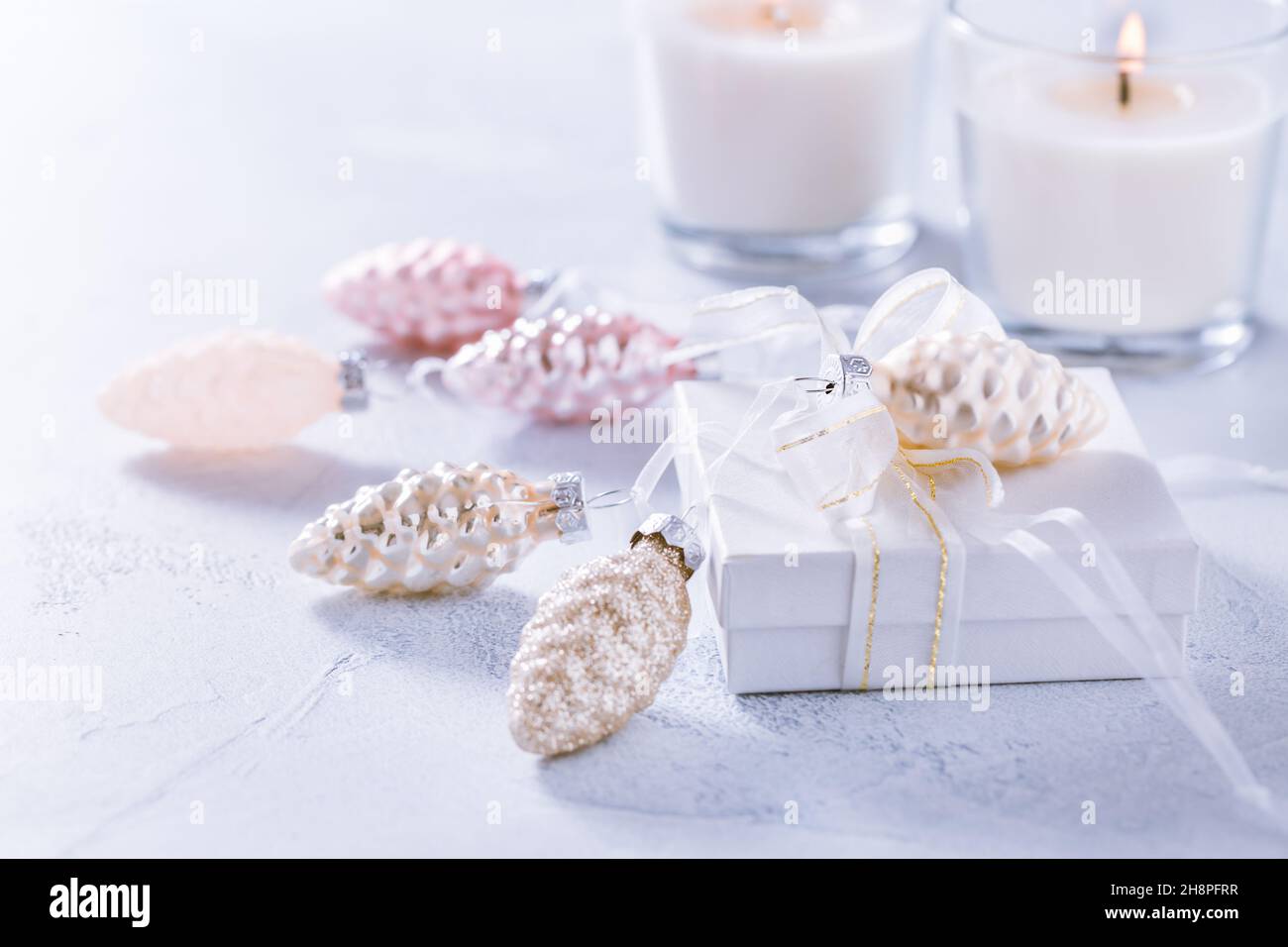 Sistemazione di ornamenti natalizi, candele e regalo di smal in bianco nevoso con spazio copia Foto Stock