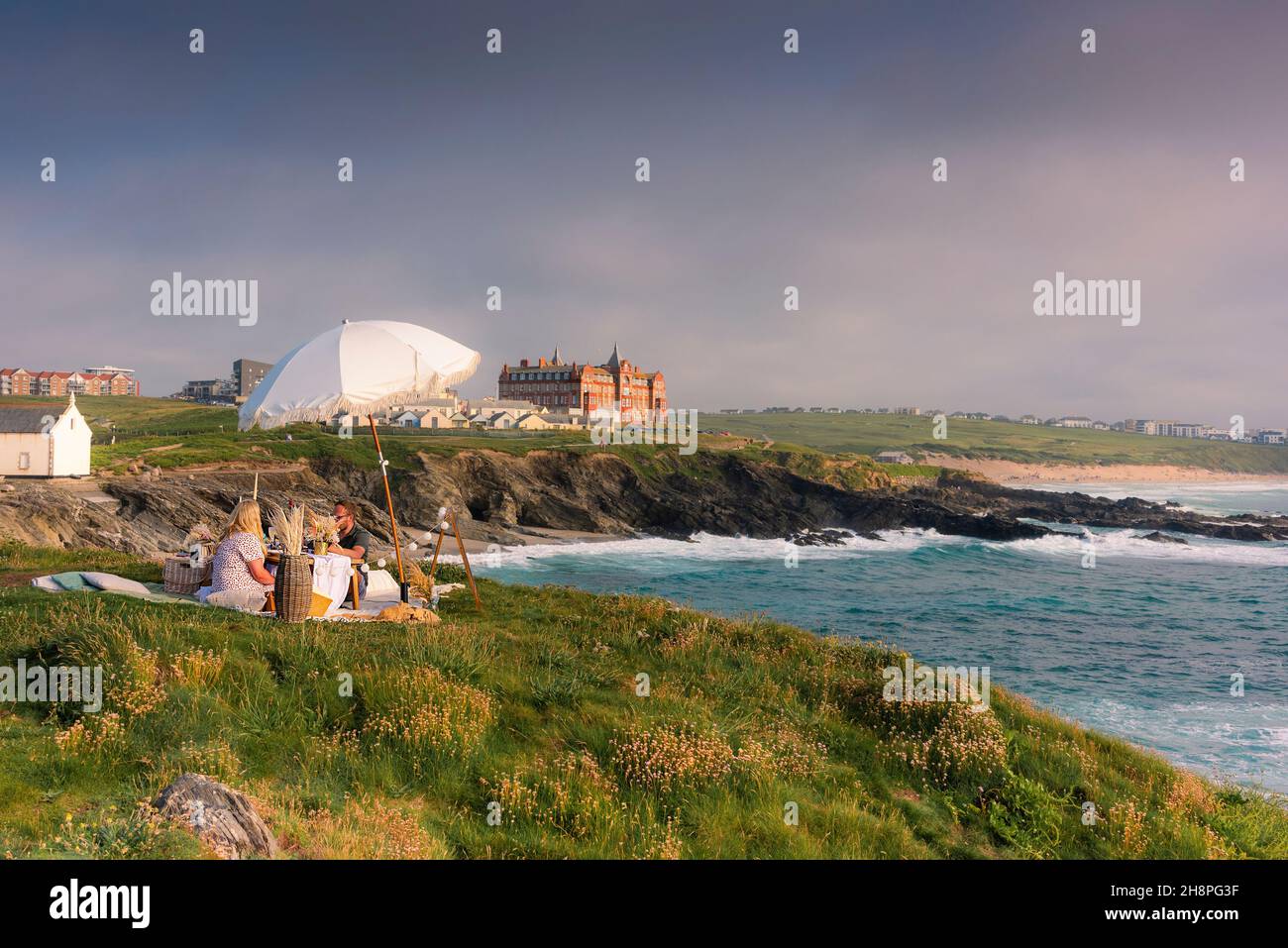 Una coppia festeggia un'occasione speciale con un romantico picnic serale a Towan Head a Newquay in Cornovaglia. Foto Stock