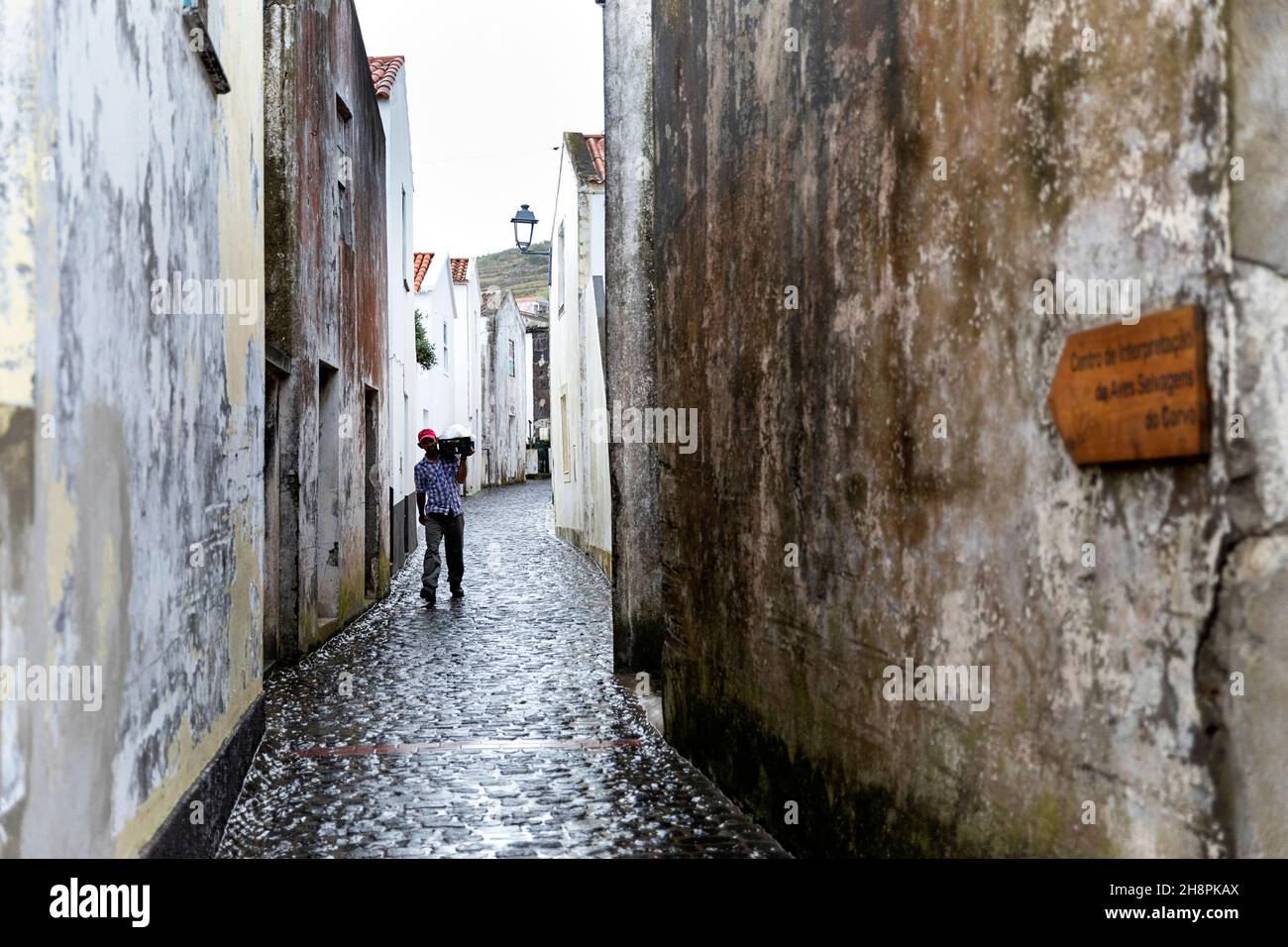 Uomo che trasporta merci per le strade di Vila do Corvo, isola di Corvo Azzorre Portogallo Foto Stock