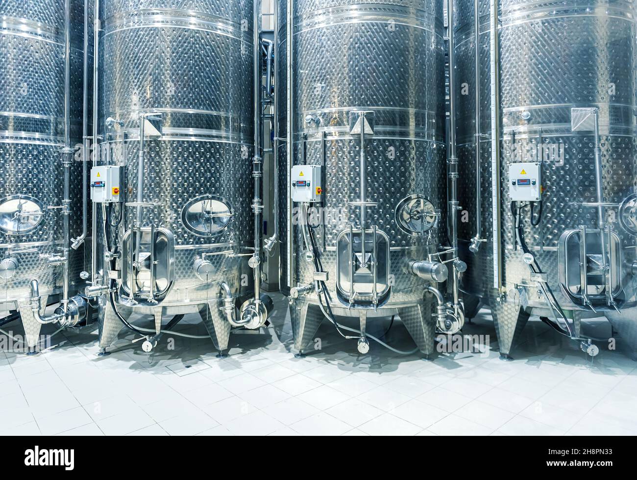 Vasche d'acciaio per la fermentazione di uve in fila. Interni moderni di una cantina Foto Stock