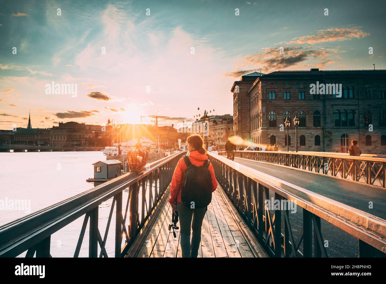 Stoccolma, Svezia. Giovane donna caucasica Lady turista viaggiatore a piedi sul famoso Skeppsholmsbron - Skeppsholm Bridge. Luogo popolare, punto di riferimento e. Foto Stock