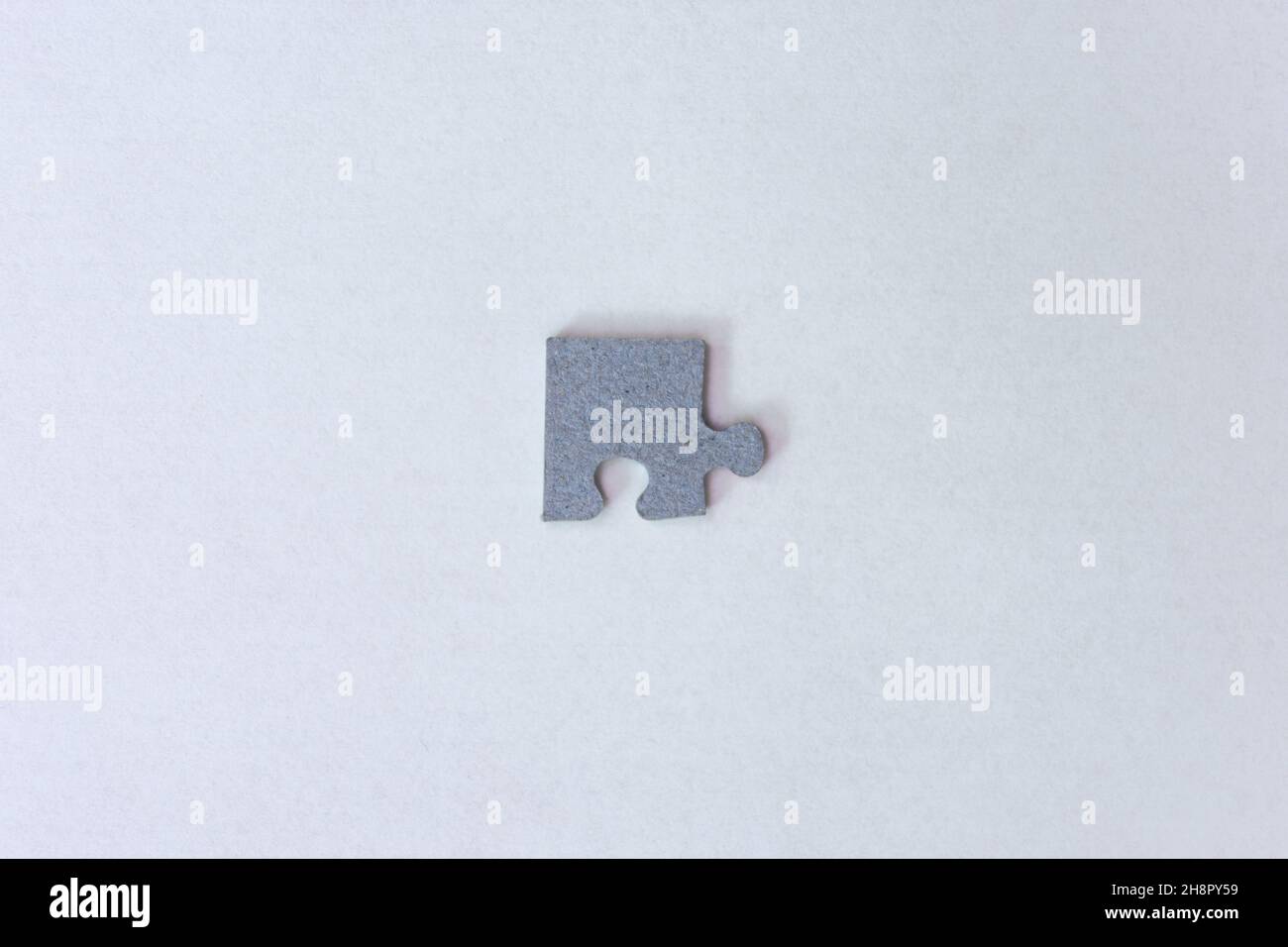 un pezzo di puzzle dal retro su uno sfondo chiaro Foto Stock