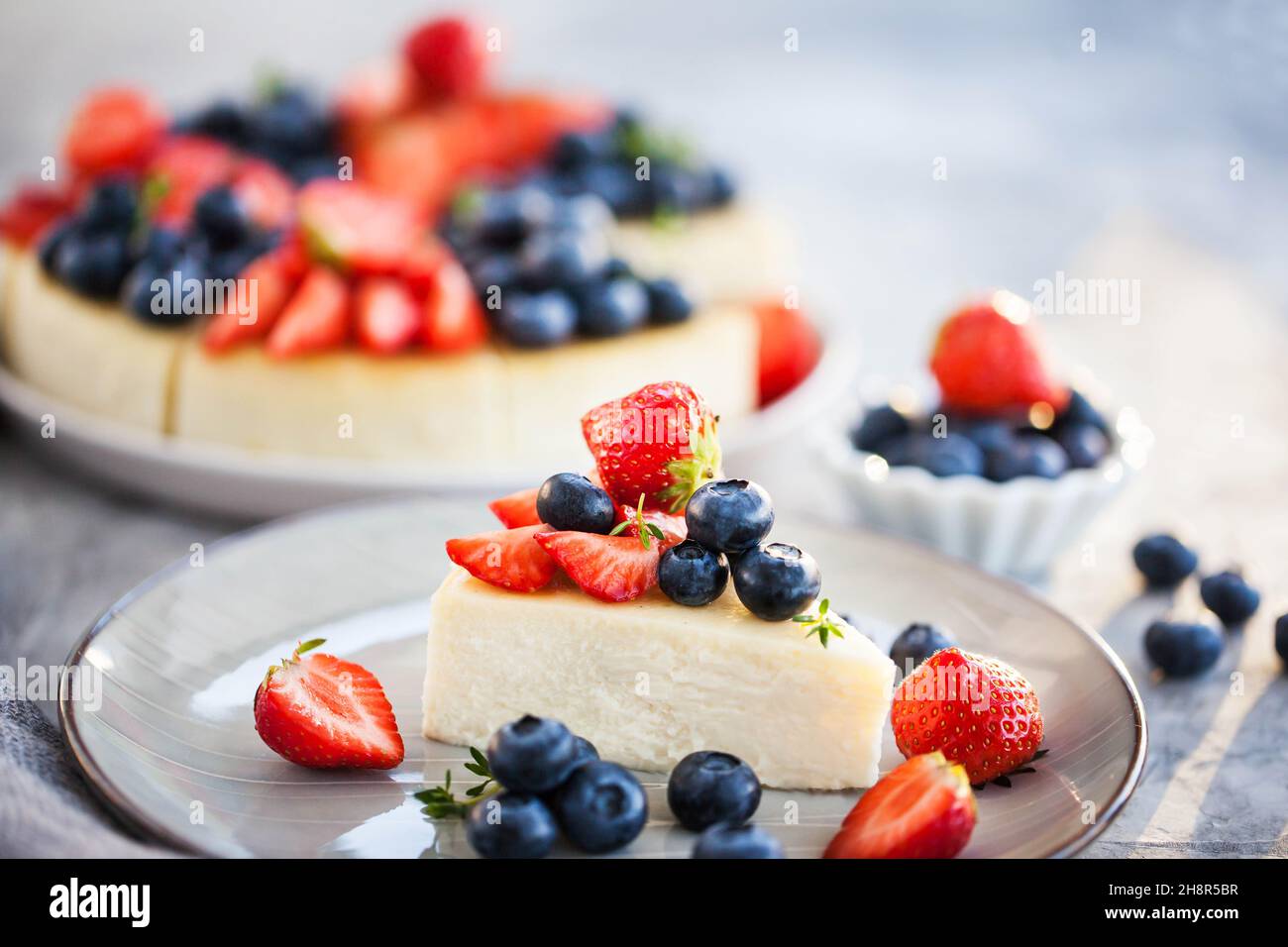 Cheesecake alla vaniglia di New York decorata con mirtilli freschi e fragole Foto Stock