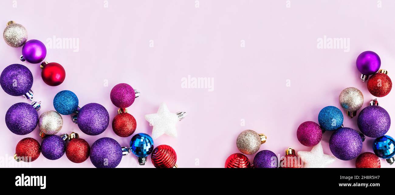 Palline natalizie colorate banner vacanza, sfondo rosa Foto Stock