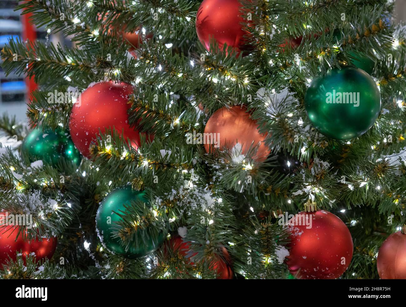 Palline di Natale rosse e verdi su un albero di Natale con una ghirlanda. Foto Stock
