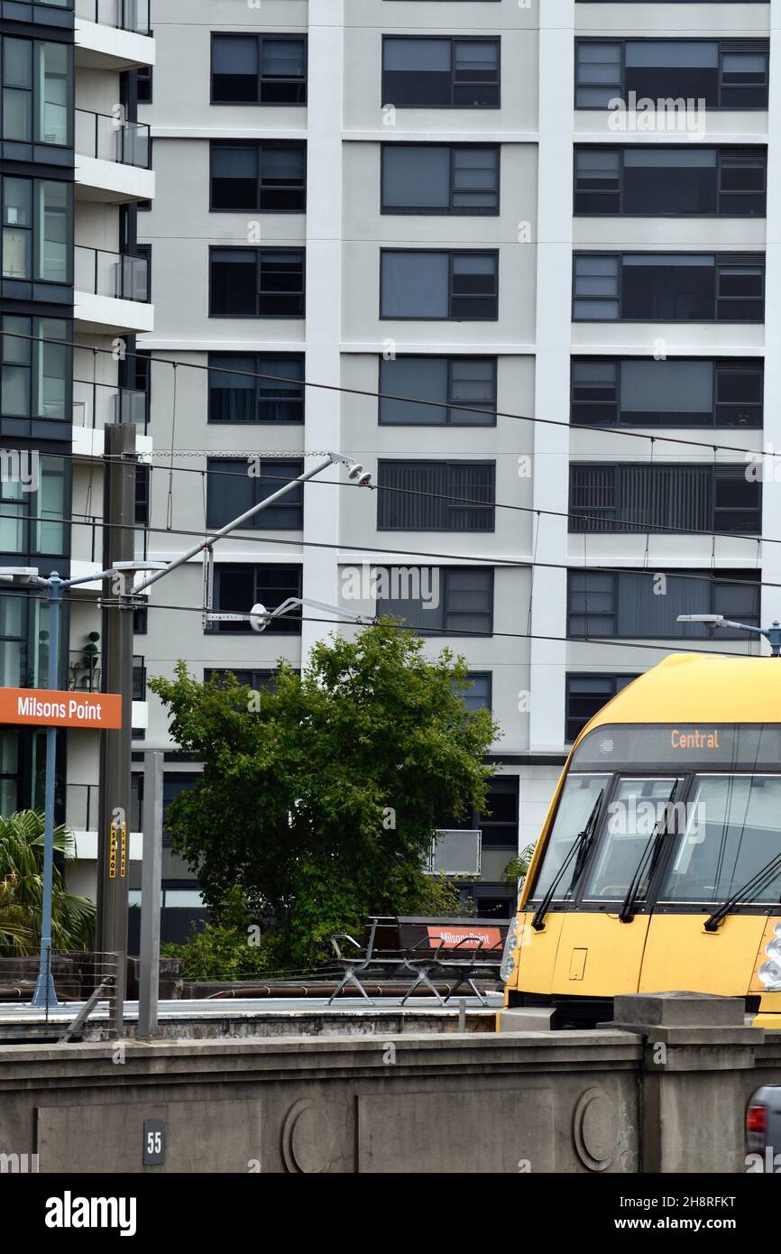 Il treno porta alla stazione ferroviaria di Milsons Point vicino al Sydney Harbour Bridge Foto Stock