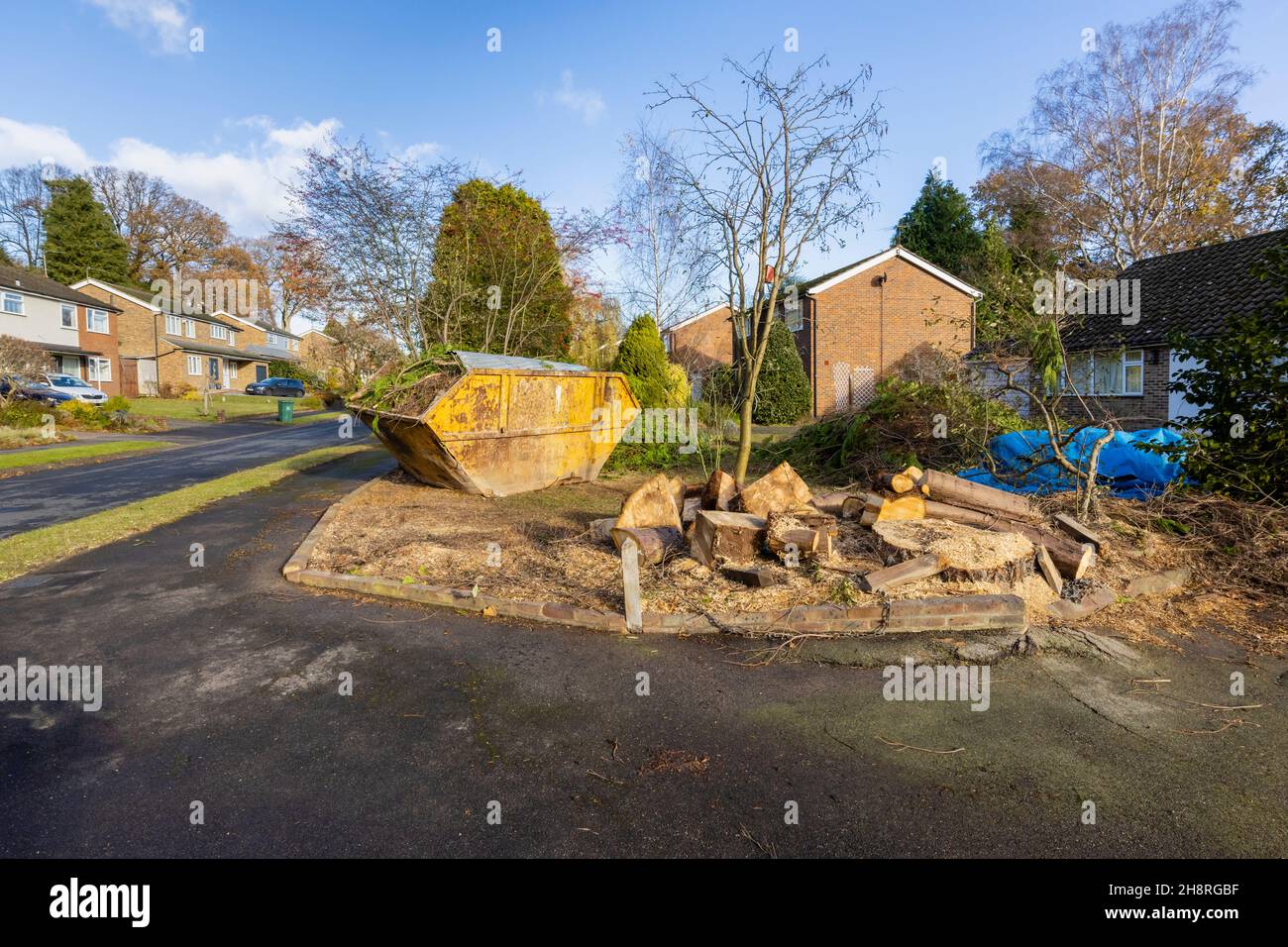 Un grande arrugginito, rifiuti di rifiuti martoriati saltare pieno di rami e rifiuti di giardino sul giardino di fronte di una strada a Surrey, nel sud-est dell'Inghilterra Foto Stock