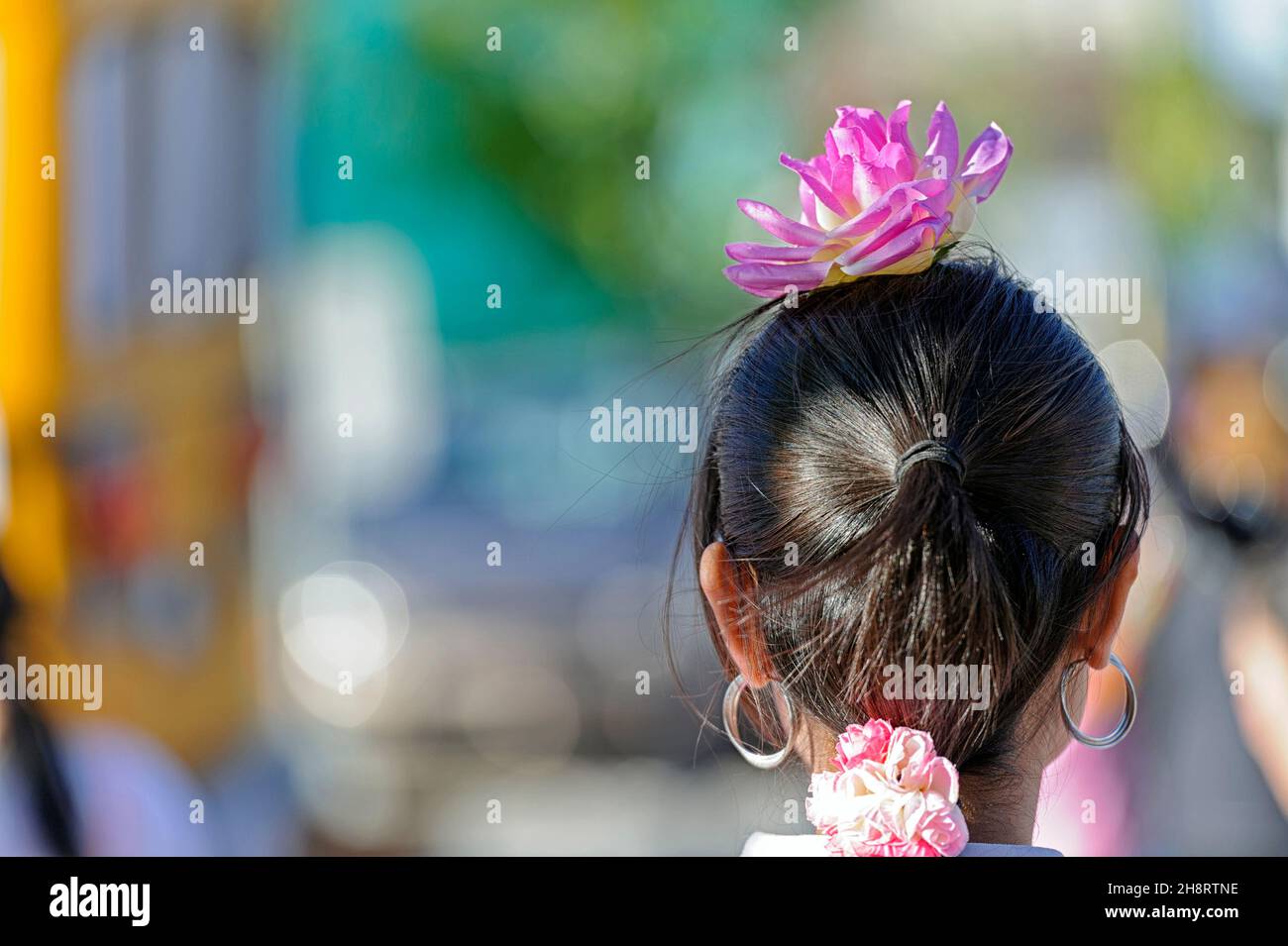 Una giovane ragazza asiatica che indossa un fiore di loto decorativo e spirituale Nelumbo nucifera in un festival culturale Foto Stock