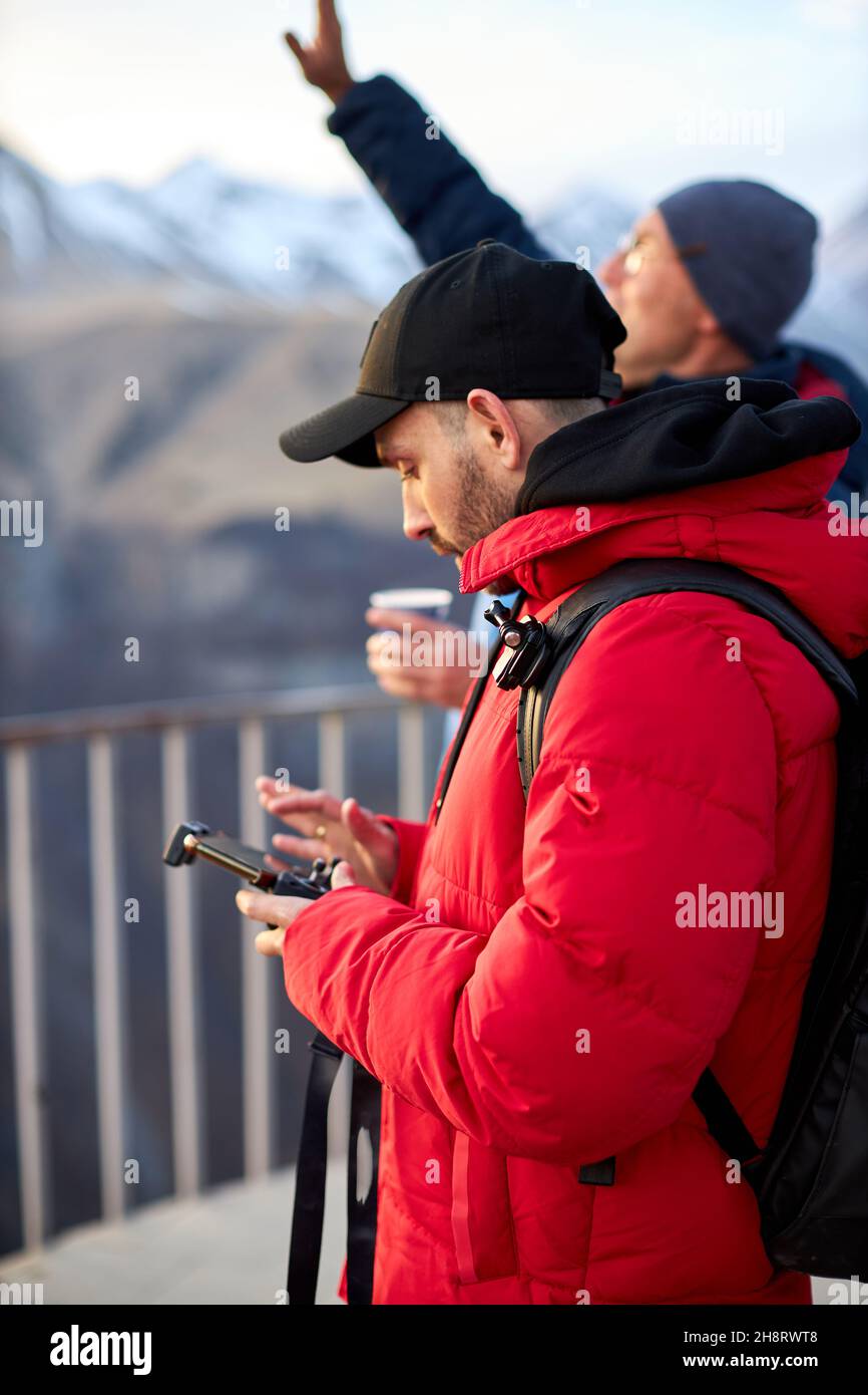 Lancio di un drone in montagna. Tourist controlla il drone dal telecomando con uno smartphone Foto Stock