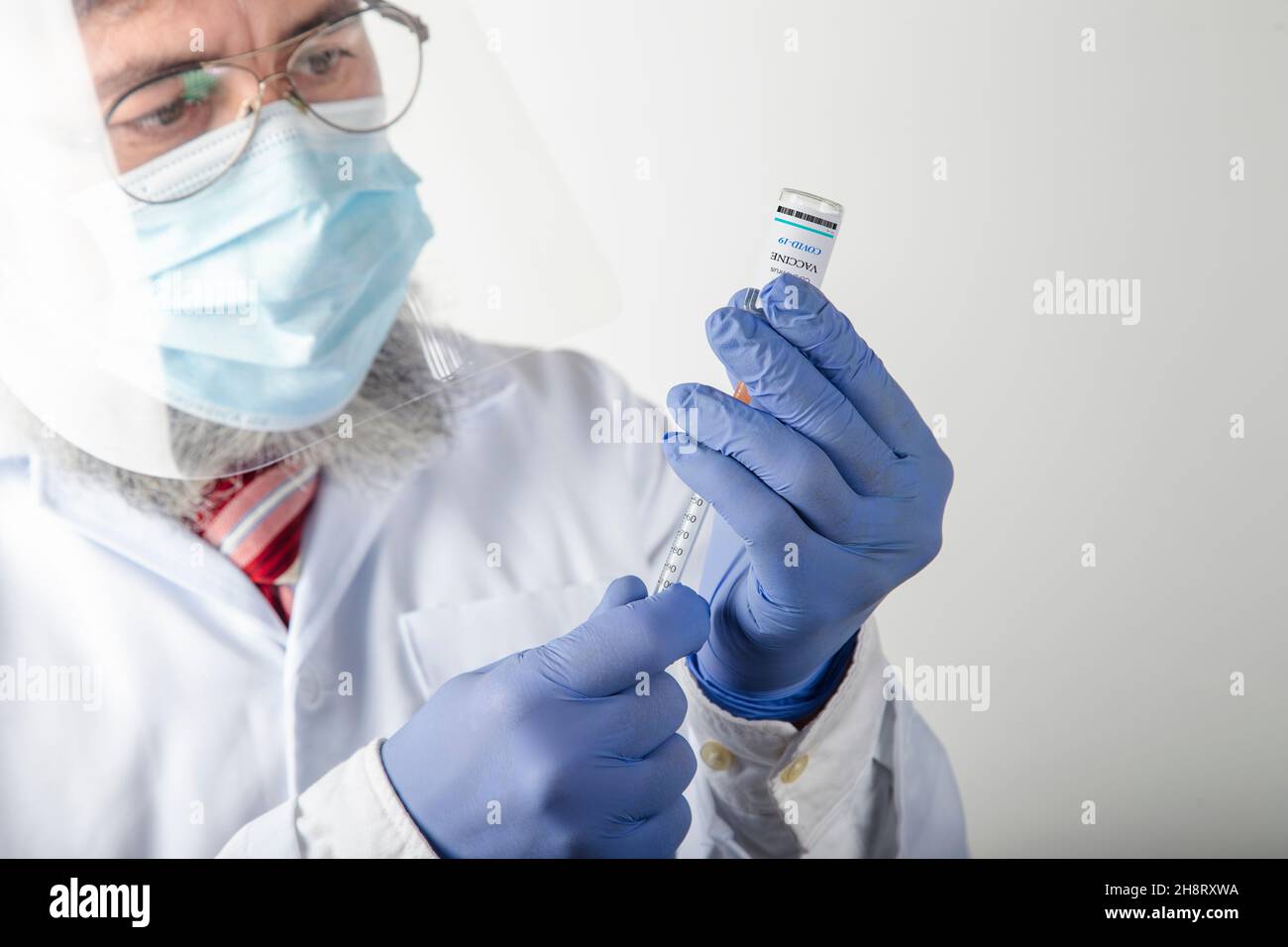 Il primo piano di un medico competente prepara il vaccino prima dell'iniezione Foto Stock