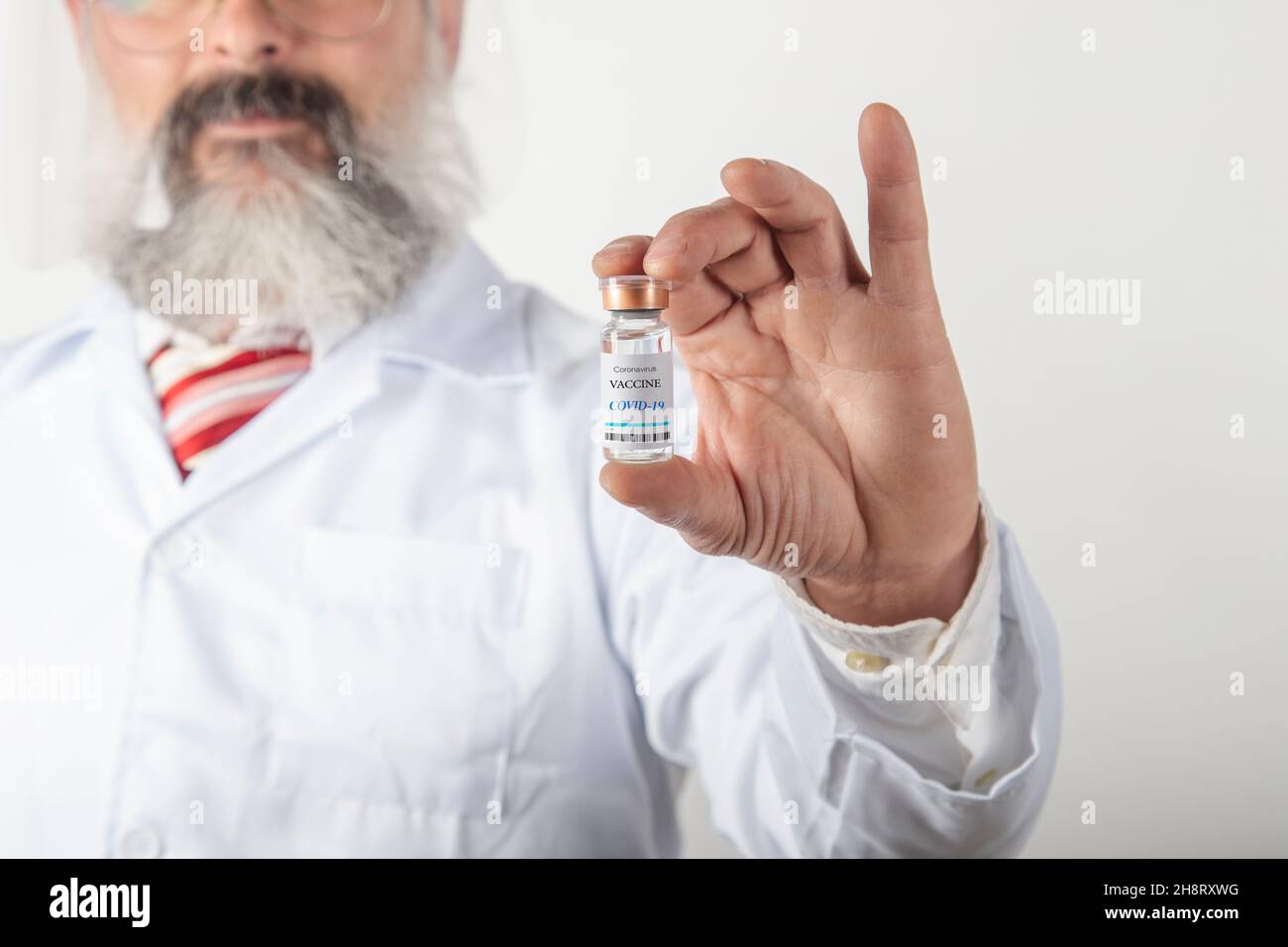 Il medico tiene la provetta con il vaccino Coronavirus 2019. Concetto di assistenza sanitaria. Campagna di vaccinazione del Covid Foto Stock