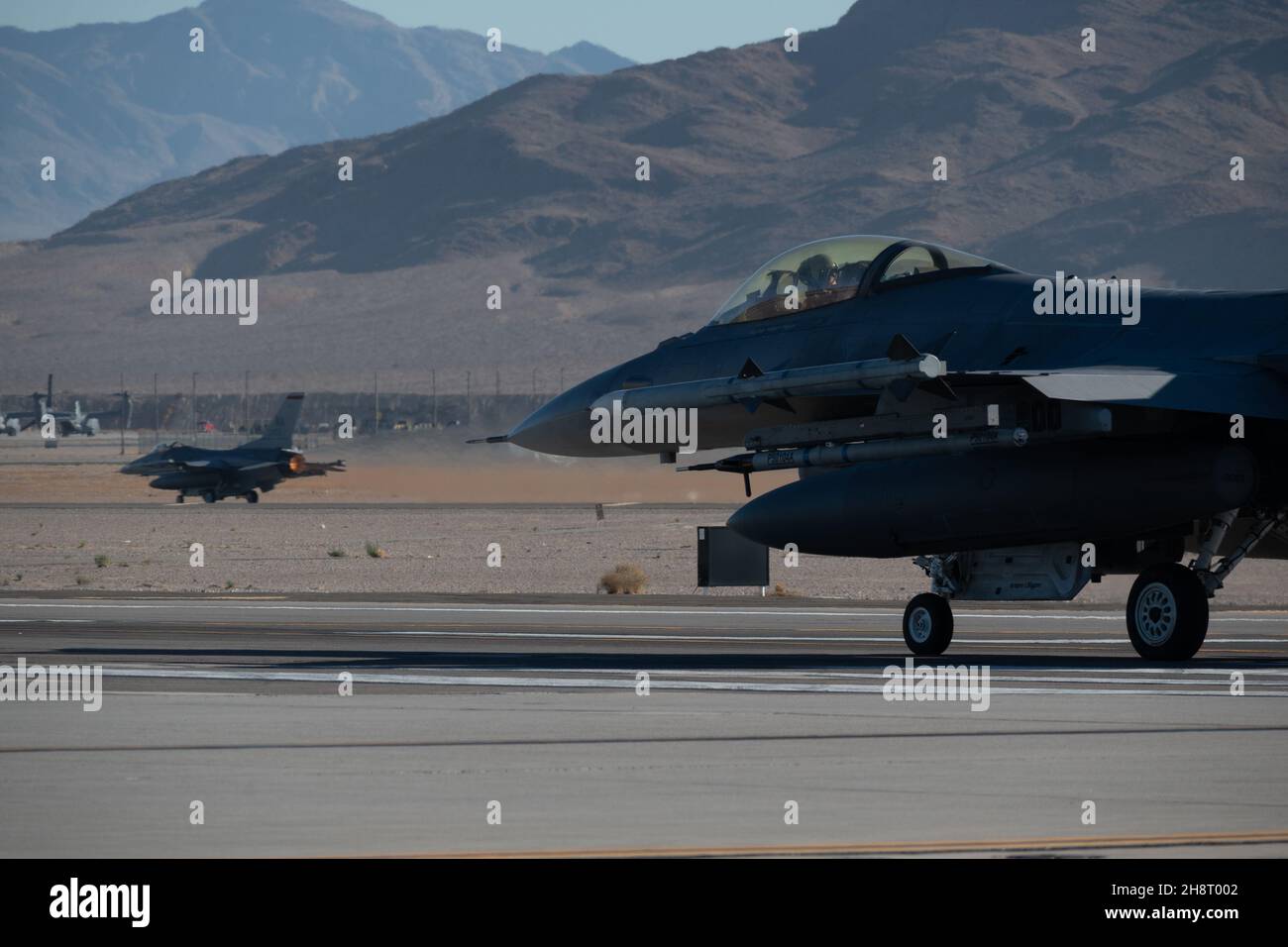 Un paio di F-16 Fighting Falcons decollo durante l'integrazione della scuola di armi alla base dell'aeronautica di Nellis, Nevada, 30 novembre 2021. La U.S. Air Force Weapons School insegna corsi di istruttori di livello laureato che forniscono una formazione avanzata nell'impiego di armi e tattiche a ufficiali e specialisti arruolati delle forze aeree di combattimento e mobilità. (STATI UNITI Foto Air Force di Michael J. Hasenauer) Foto Stock