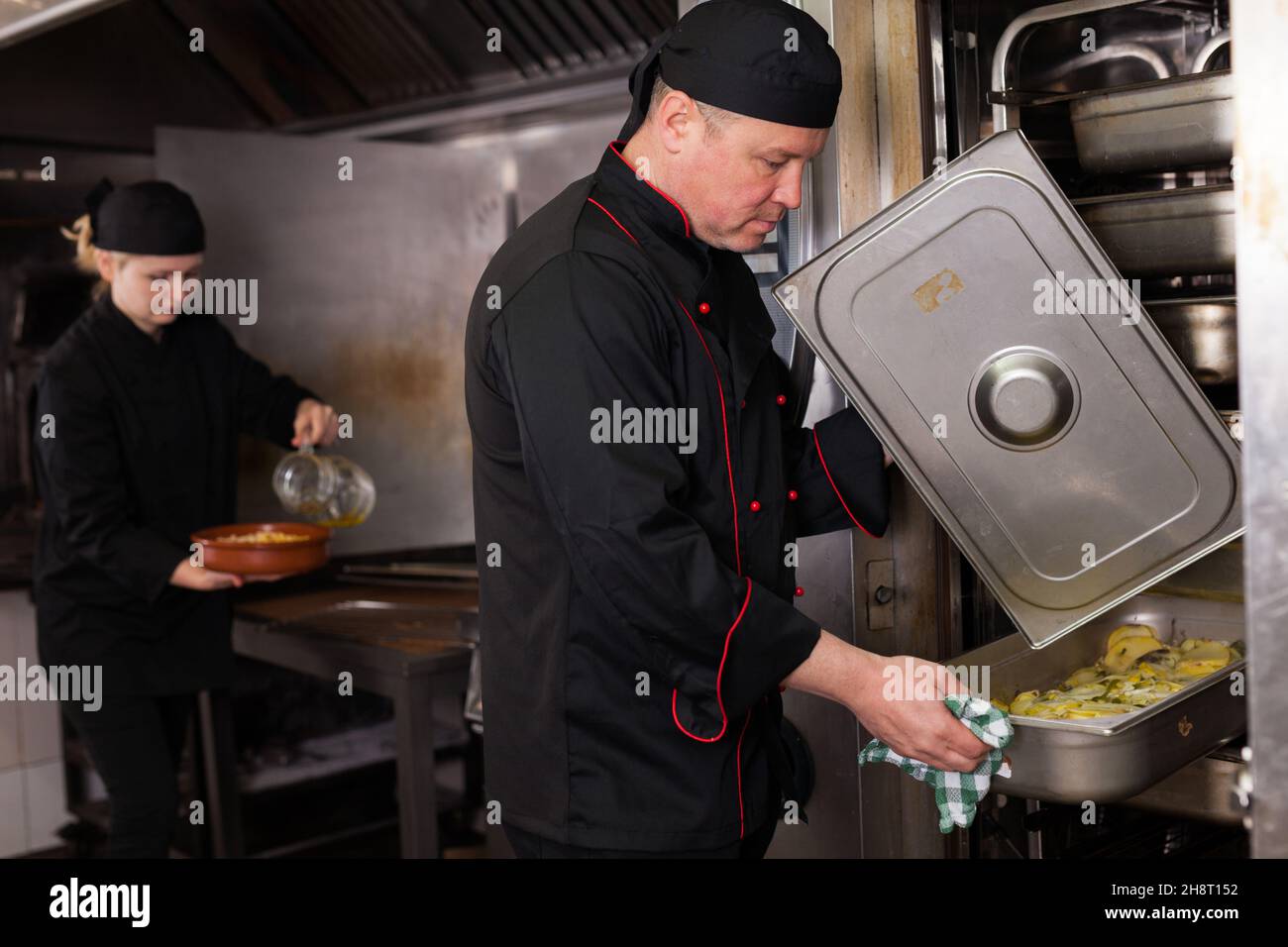 Chef preparandosi piatto fuori dal forno Foto Stock