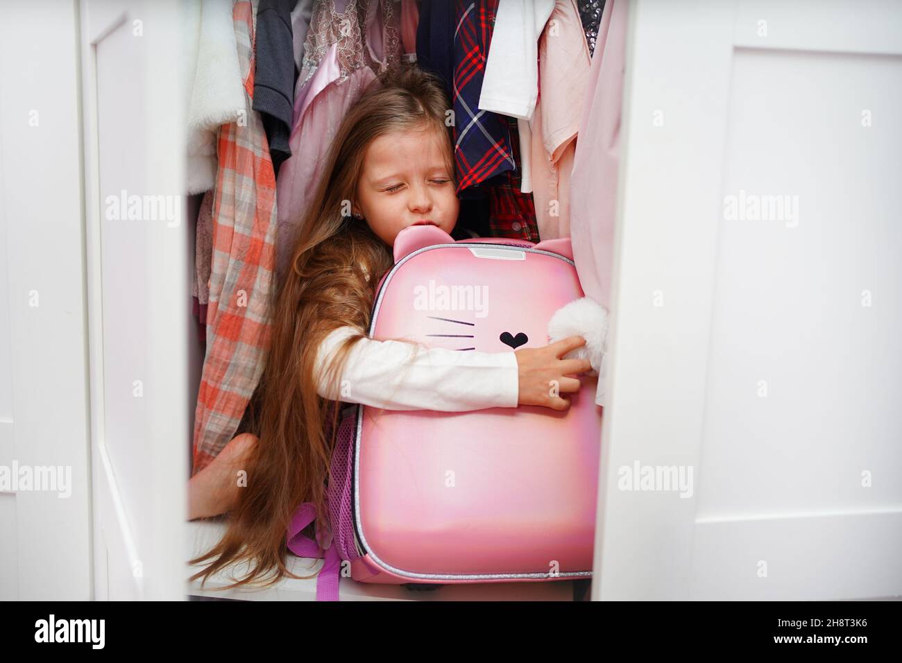 La studentessa si nascose nell'armadio, la ragazza non vuole andare a scuola a causa del bullismo. Foto Stock