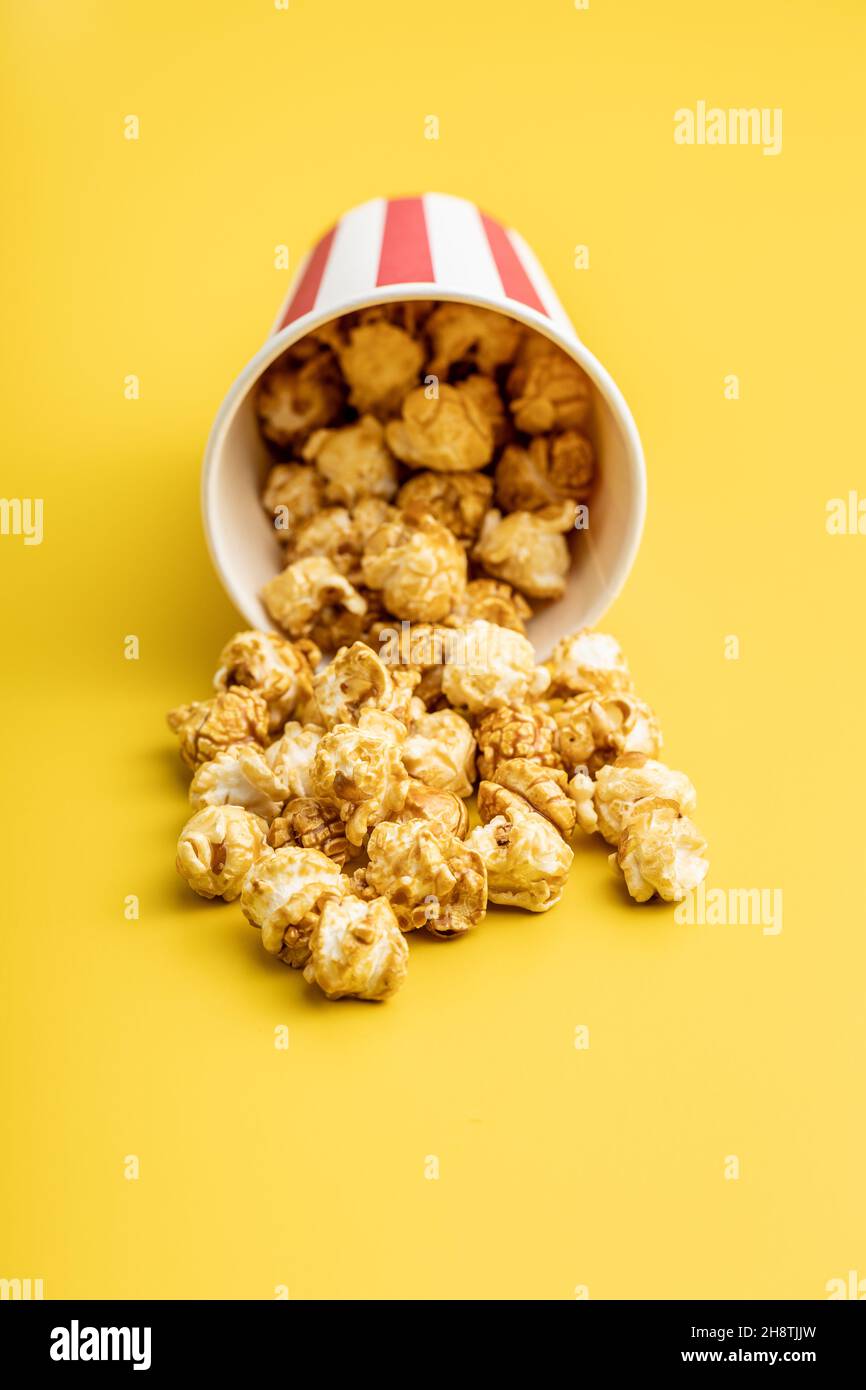 Popcorn caramello dolce in tazza su sfondo giallo. Foto Stock