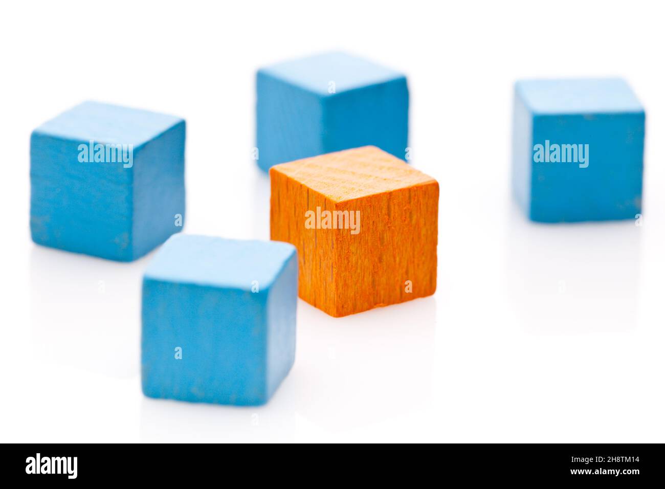 Un cubo in arancione e molti cubetti blu Foto Stock