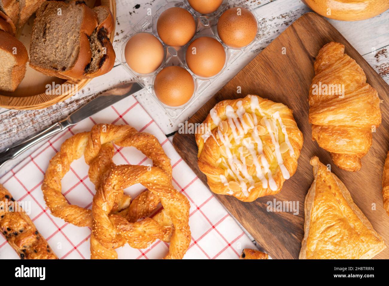 Vari tipi di pane e uova su un panno bianco rosso. Messa a fuoco selettiva. Foto Stock