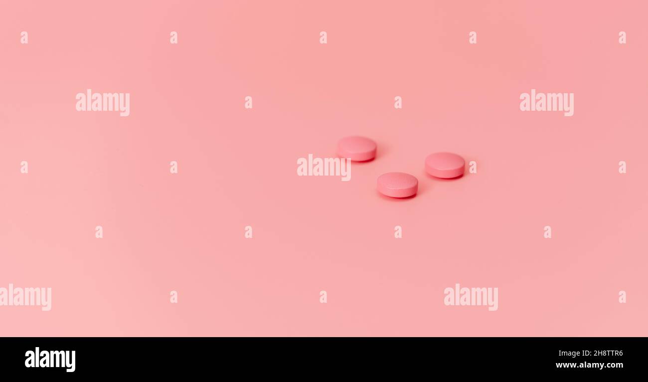 Compresse rotonde di rosa vecchio su sfondo rosa. Industria farmaceutica. Sanità e medicina. Farmaco da prescrizione. Banner farmacia online. Nuovo Foto Stock