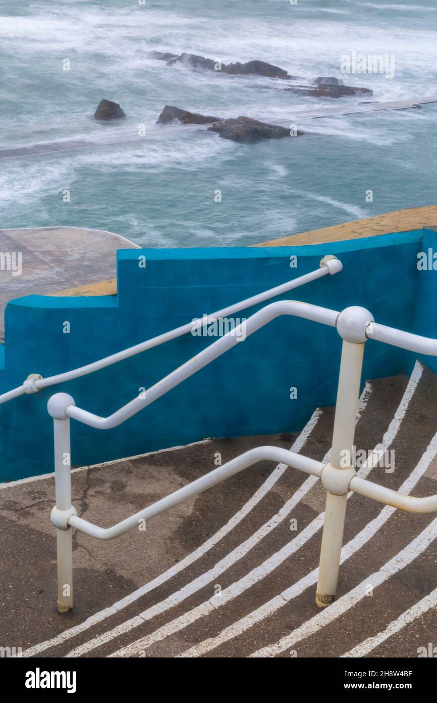 Scalini che conducono alla piscina del Mare di Bude a Summerleaze Beach, Bude, Cornovaglia Nord, Regno Unito in una fredda giornata ventosa nel mese di novembre - in parte piscina di marea artificiale Foto Stock