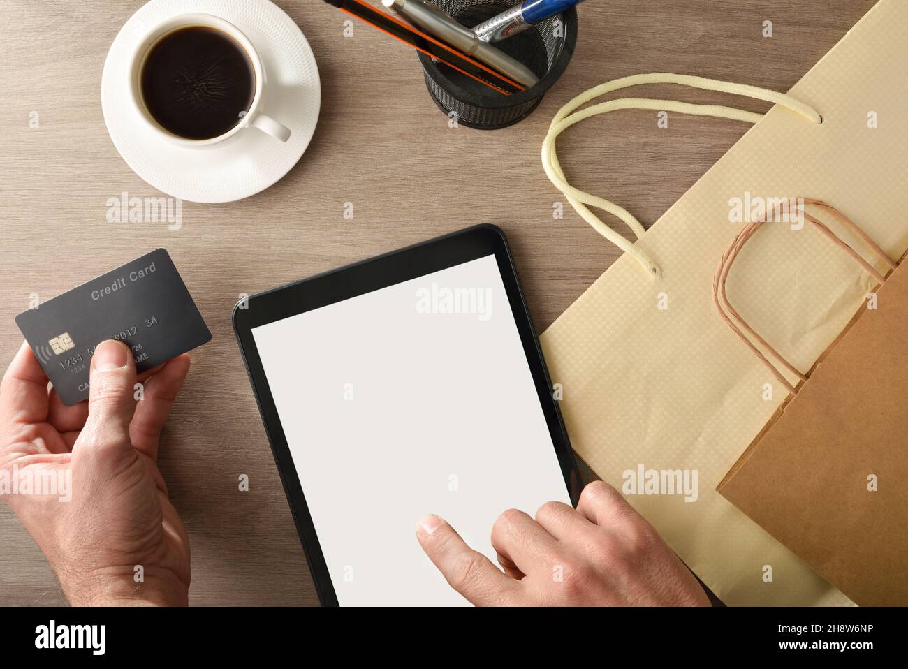 Fare un acquisto di Internet da casa da un tablet sulla panca della cucina con prima colazione. Vista dall'alto. Composizione orizzontale. Foto Stock