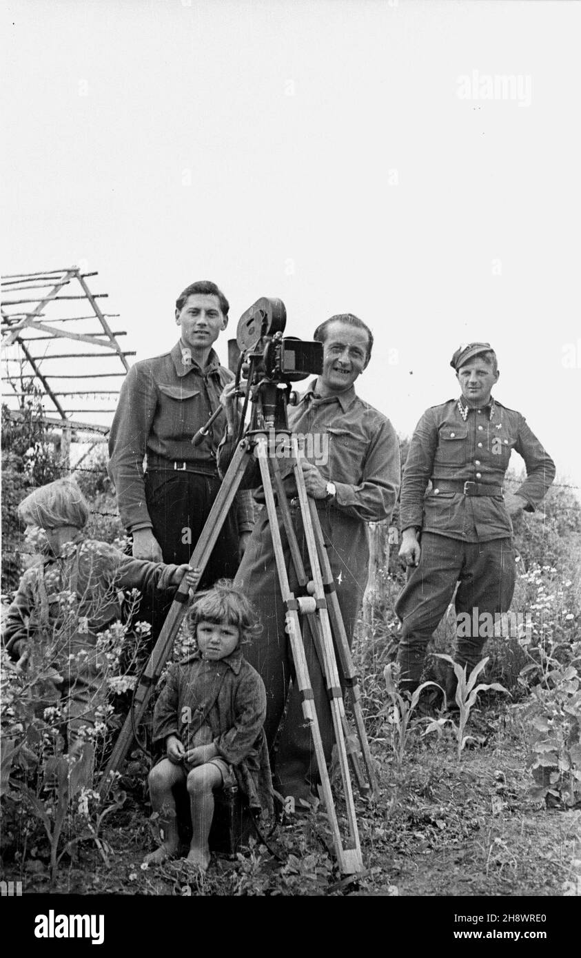 Okolice Warki, 1946. Pas zniszczeñ wojennych objêtych programem Odbudowy Gospodarczej Terenów Zniszczonych po II wojnie œwiatowej. NZ. Mieczys³aw Wiesio³ek (L) i W³adys³aw Forbert (C), operatorzy Polskiej Kroniki Filmowej, rejestruj¹ na taœmie filmowej zniszczenia i odbudowê wsi. Gr PAP/Bogus³aw Lambach Dok³adny miesi¹c i dzieñ wydarzenia nieustalone. Zona di Warka, 1946. Le are del territorio distrutto della seconda Guerra Mondiale coperto dal programma di ricostruzione economica dei territori distrutti durante la seconda Guerra Mondiale. Nella foto: Cinefilo polacco Mieczyslaw Wiesiolek (da sinistra) e Wladyslaw Foto Stock