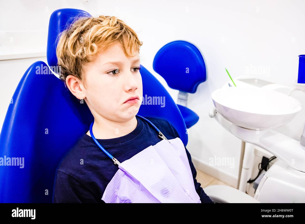 Visita annuale al dentista di un bambino con un volto strano. Foto Stock