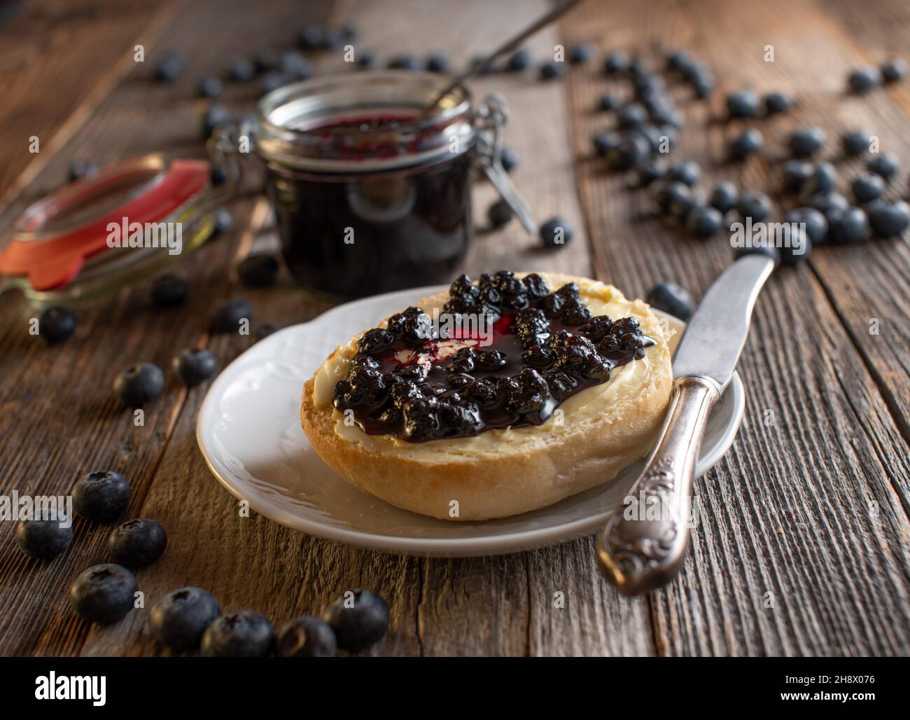 Bun tedesco con burro e marmellata di mirtilli fatta in casa Foto Stock