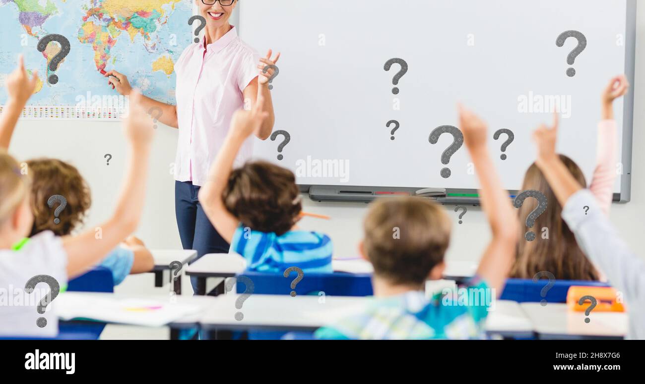 Composizione digitale di punti interrogativi sugli studenti con insegnante con risposta a mano sollevata in aula Foto Stock