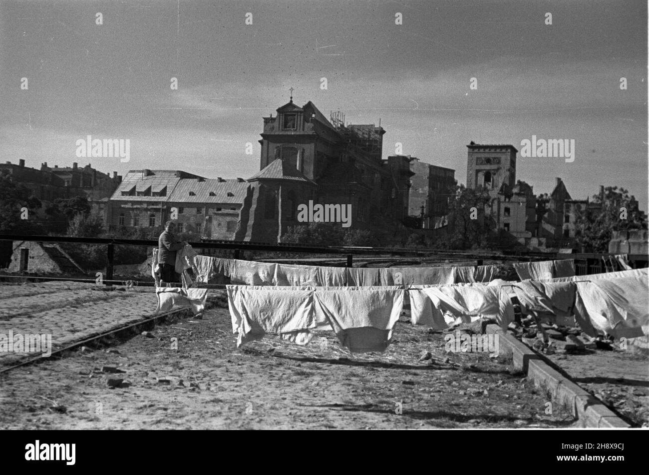 Warszawa, 1946-01-01. Kobieta wywiesza pranie na prowizorycznie umocowanych sznurach. W tle widoczny czêœciowo zniszczony kosció³ pw. œw. Sig.ra PAP/Jerzy Baranowski Varsavia, 1 gennaio 1946. Una donna appende il lavaggio su linee di abbigliamento provvisoriamente fissate. Sullo sfondo in parte distrusse la chiesa di Sant'Anna. ms PAP/Jerzy Baranowski Foto Stock