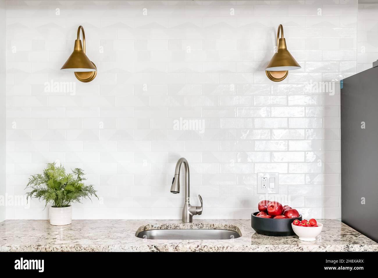 Bancone cucina in granito con piastrelle bianche e luci dorate Foto stock -  Alamy