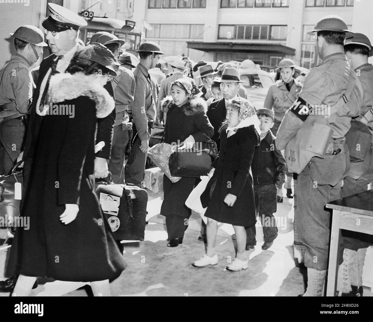 Famiglia giapponese-americana che parte per il Centro di Relocation, San Francisco, California, Stati Uniti, corpo di segnale dell'esercito degli Stati Uniti, maggio 1942 Foto Stock