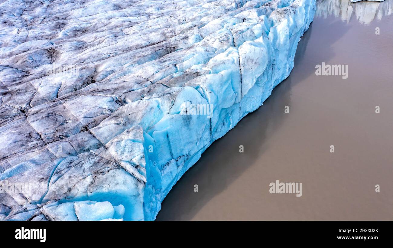 Parete frontale del ghiacciaio Fjalljokull nella laguna glaciale di Fjallsarlon, Islanda meridionale. Parte del parco nazionale Vatnajokull. Il nero in Foto Stock