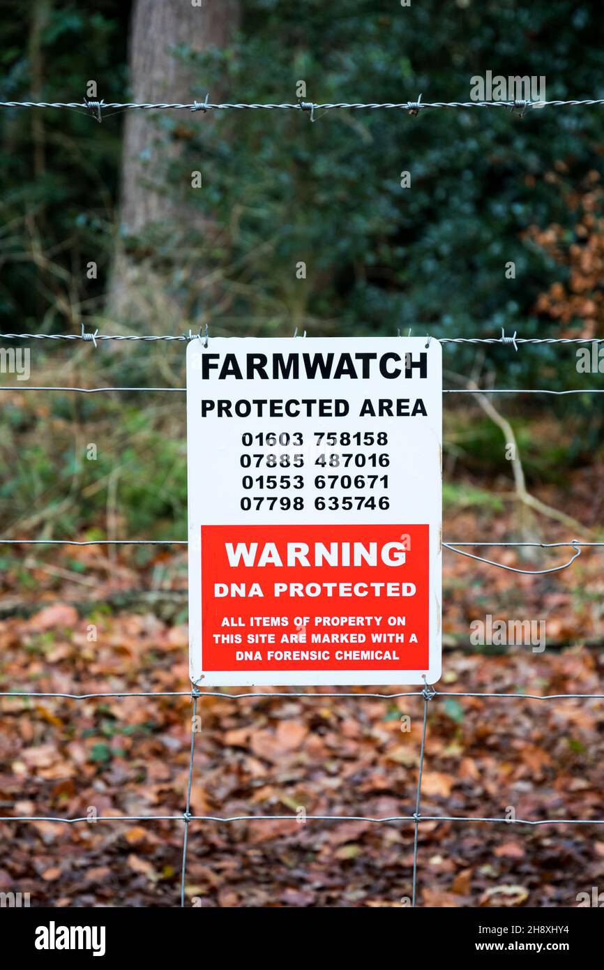 Farmwatch Area protetta segno su una recinzione intorno Norfolk Woodland. Foto Stock