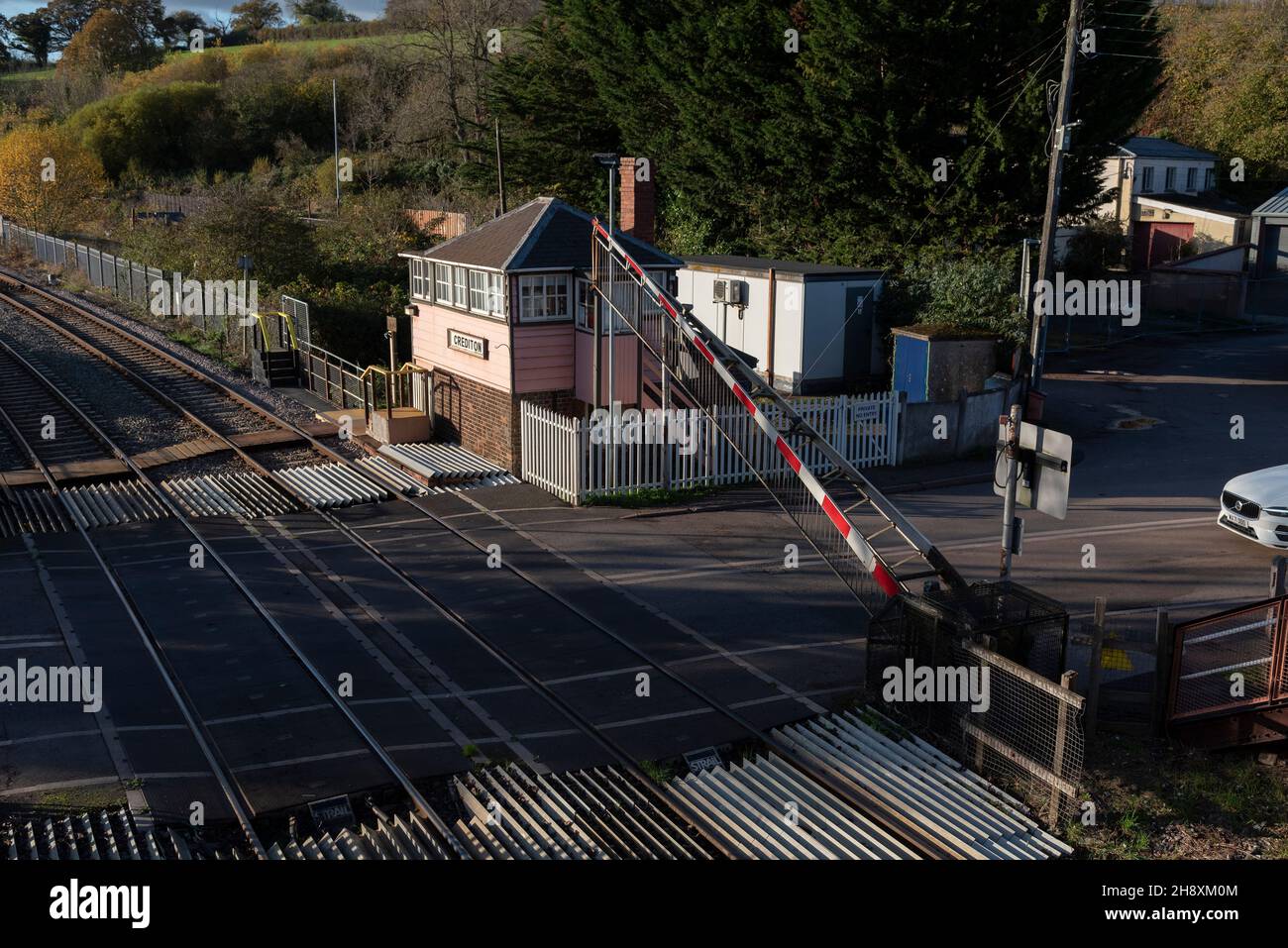 Crediton, Devon, Inghilterra. 2021. Panoramica della chiusura della barriera di attraversamento a livello, traffico a Crediton lungo la linea ferroviaria per Okehampton e Barnstable. Foto Stock