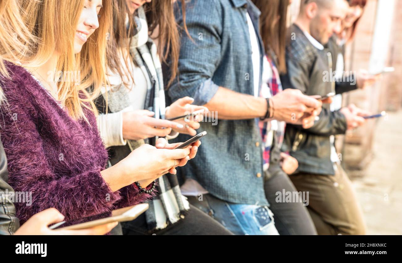 Gruppo di amici multiculturali che utilizzano lo smartphone all'università college backyard break - persone dipendenti mani da cellulare smart phone Foto Stock