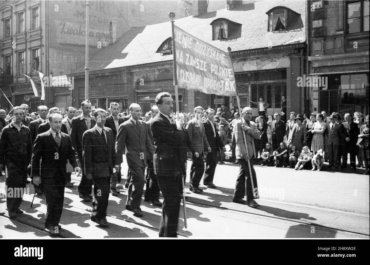 £ódŸ, 1946-05-01. Pochód pierwszomajowy na ul. Piotrkowskiej. Mê¿czyŸni nios¹ transparent z has³em: Ziemie odzyskane na zawsze polskie. W g³osowianiu odpowiemy - tak. ZE wzglêdu na ogromne zniszczenia Warszawy, w latach 1945-1948 £ódŸ pe³ni³a funkcjê zastêpczej stolicy pañstwa. ps/pp PAP/Stanis³aw Urbanowicz Lodz, 1 maggio 1946. La sfilata del giorno di maggio in via Piotrkowska. Gli uomini trasportano una bandiera che dice: Territori riguadagnati Forever della Polonia. Nel referendum diremo sì. A causa delle ingenti perdite subite da Varsavia Lodz fu il capitale temporaneo della Polonia tra il 1945 e il 1948. ps/pp PAP/Bogusl Foto Stock