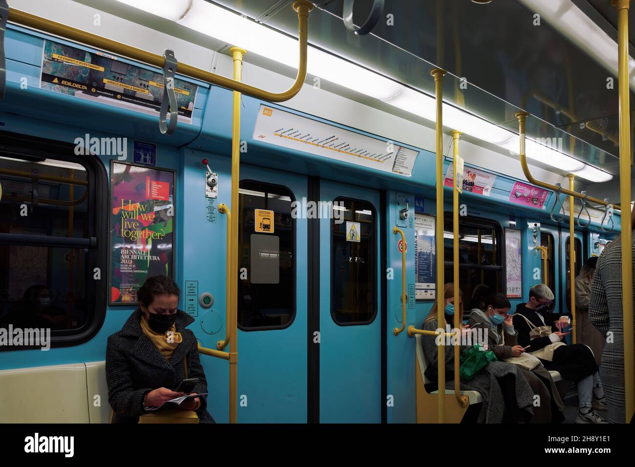 Milano, Italia persone che indossano cocide-19 maschere all'interno della metropolitana pullman. Folla con coronavirus protezione del viso utilizzando i mezzi pubblici sotterranei nel centro della città della capitale lombarda. Foto Stock
