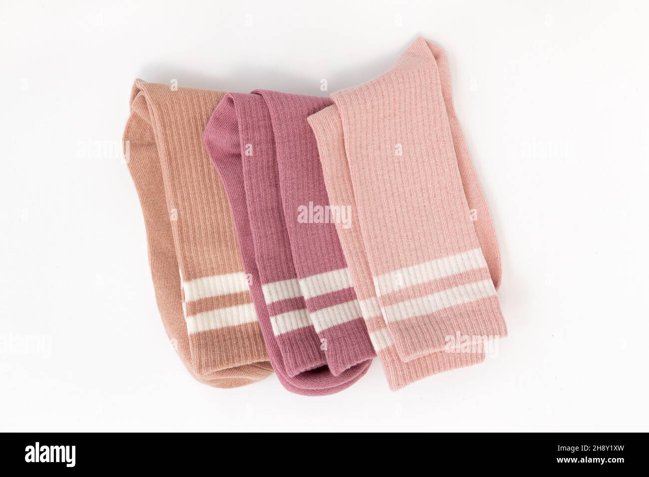 tre calze in cotone beige, rosa e rosso isolate su sfondo bianco, accessori caldi, vista dall'alto Foto Stock