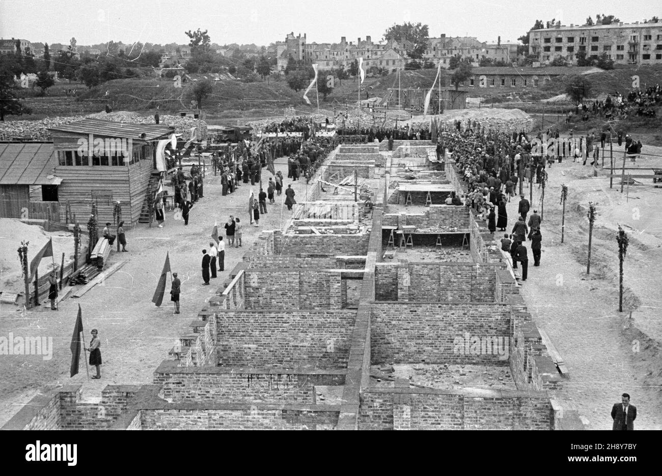 Warszawa, 1946-07-07. Uroczystoœæ wmurowania kamienia wêgielnego pod funsetty pierwszego domu mieszkalnego na tzw. XI kolonii Warszawskiej Spó³dzielni Mieszkaniowej na ¯oliborzu. NZ. Trybuna honorowa z zaprotzonymi goœæmi i funsettanta wznoszonego domu. pw PAP/Stanis³aw D¹browiecki Varsavia, 7 luglio 1946. Una cerimonia di posa in pietra angolare per la prima casa della cosiddetta colonia XI dell'Associazione degli alloggi di Varsavia nel distretto di Zoliborz. Nella foto: Un podio con gli ospiti inivted e le fondamenta della casa in costruzione. pw PAP/Stanislaw Dabrowiecki Foto Stock