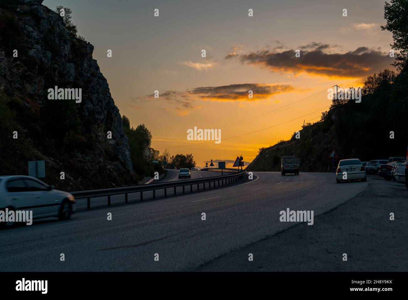 Ankara, Turchia - Settembre 18 2021: Traffico che scorre su una strada divisa in pendenza al tramonto, in salita. Foto Stock