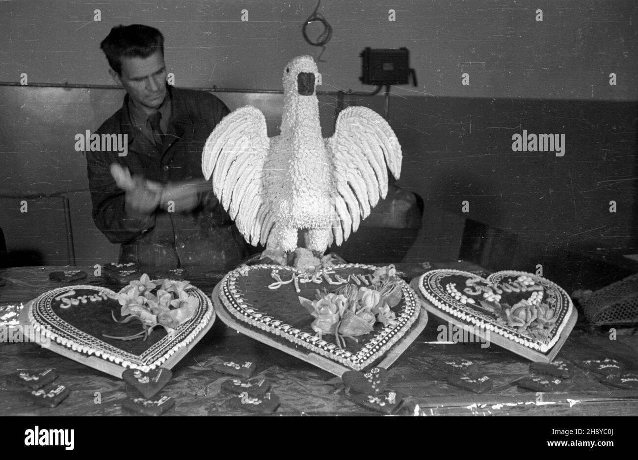 Toruñ, 1946-08-01. Dzie³o spo³emowskich cukierników - pierniki w kszta³cie serca, bogato zdobione, z napisami Toruñ i Spo³em. Za nimi bia³y orze³, te¿ dzie³o cukierników z Zak³adów Wytwórczych Spo³em. mw PAP/Jerzy Baranowski Torun, 1946 agosto. Cuori di pan di zenzero, con ricchi ornamenti, prodotti presso lo stabilimento di produzione di Spolem. Dietro di loro un'aquila bianca, prodotta anche nello stabilimento di Spolem. mw PAP/Jerzy Baranowski Foto Stock