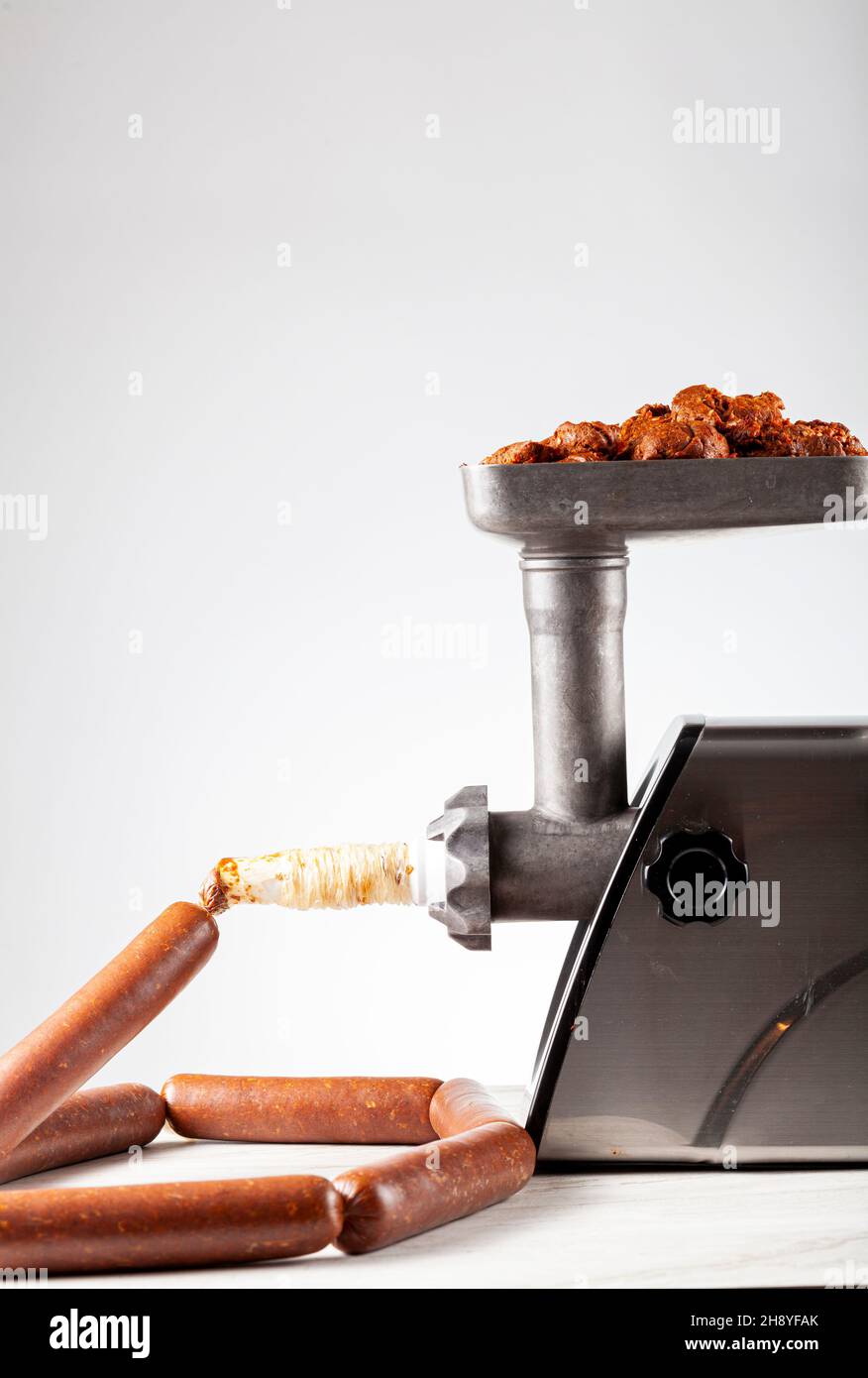 Primo piano immagine isolata di sucuk o salsiccia fatta in casa che è stato riempito in involucro utilizzando dispositivo di stuffer elettrico. Foto Stock