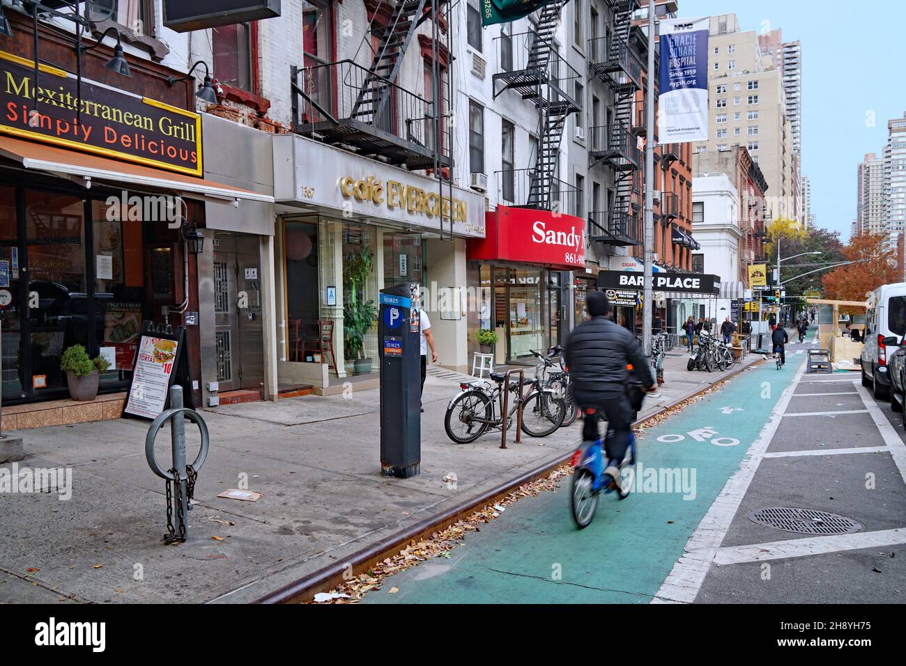 New York, NY- 17 novembre 2021: Il ciclismo è diventato un mezzo di trasporto popolare, con piste ciclabili separate sulle strade principali, come ad esempio su First Foto Stock