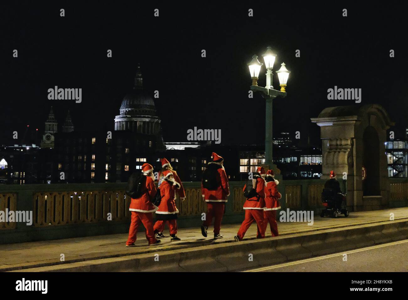 Londra, Regno Unito, 2 dicembre 2021, centinaia di escursionisti, Gli utenti in sedia a rotelle e i corridori hanno partecipato all'evento festivo 'Santa in the City' 5K. I partecipanti che hanno donato Santa Suits e Beards hanno seguito un percorso intorno alla Southbank e alla City di Londra - alcuni erano in squadre in esecuzione per il Maggies Centre, la Royal Marsden Cancer Charity, Single Homeless Project e molte altre cause. Credit: Undicesima ora Fotografia/Alamy Live News Foto Stock